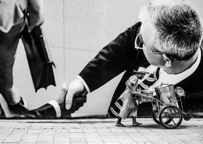 Straßenverkäufer schiebt Wagen vor großer Werbewand mit Geschäftsleuten Schwarz-Weiß