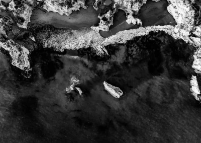 Luftaufnahme von Küste mit Felsen und Wellen Schwarz-Weiß