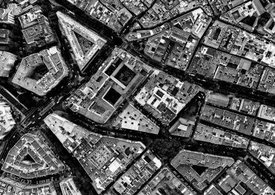 Luftaufnahme einer Stadt mit dichten Gebäuden und Straßen in geometrischer Anordnung Schwarz-Weiß