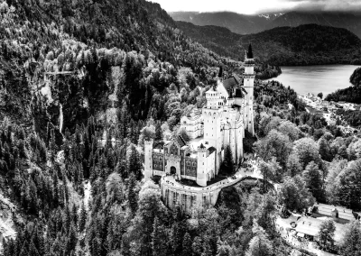 Schloss Neuschwanstein inmitten von Wald und Bergen Schwarz-Weiß