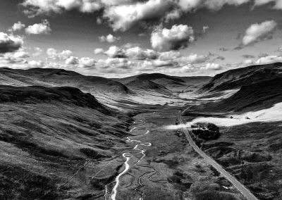 Schwarz-Weiß Landschaft mit Hügeln, Tal und geschwungenem Flusslauf