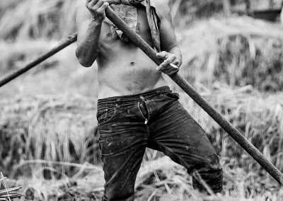 Mann mit Werkzeug steht in einem Feld Schwarz-Weiß Portrait