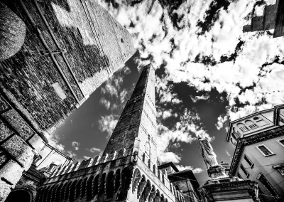 Historischer Turm in einer Altstadt aus niedriger Perspektive Schwarz-Weiß